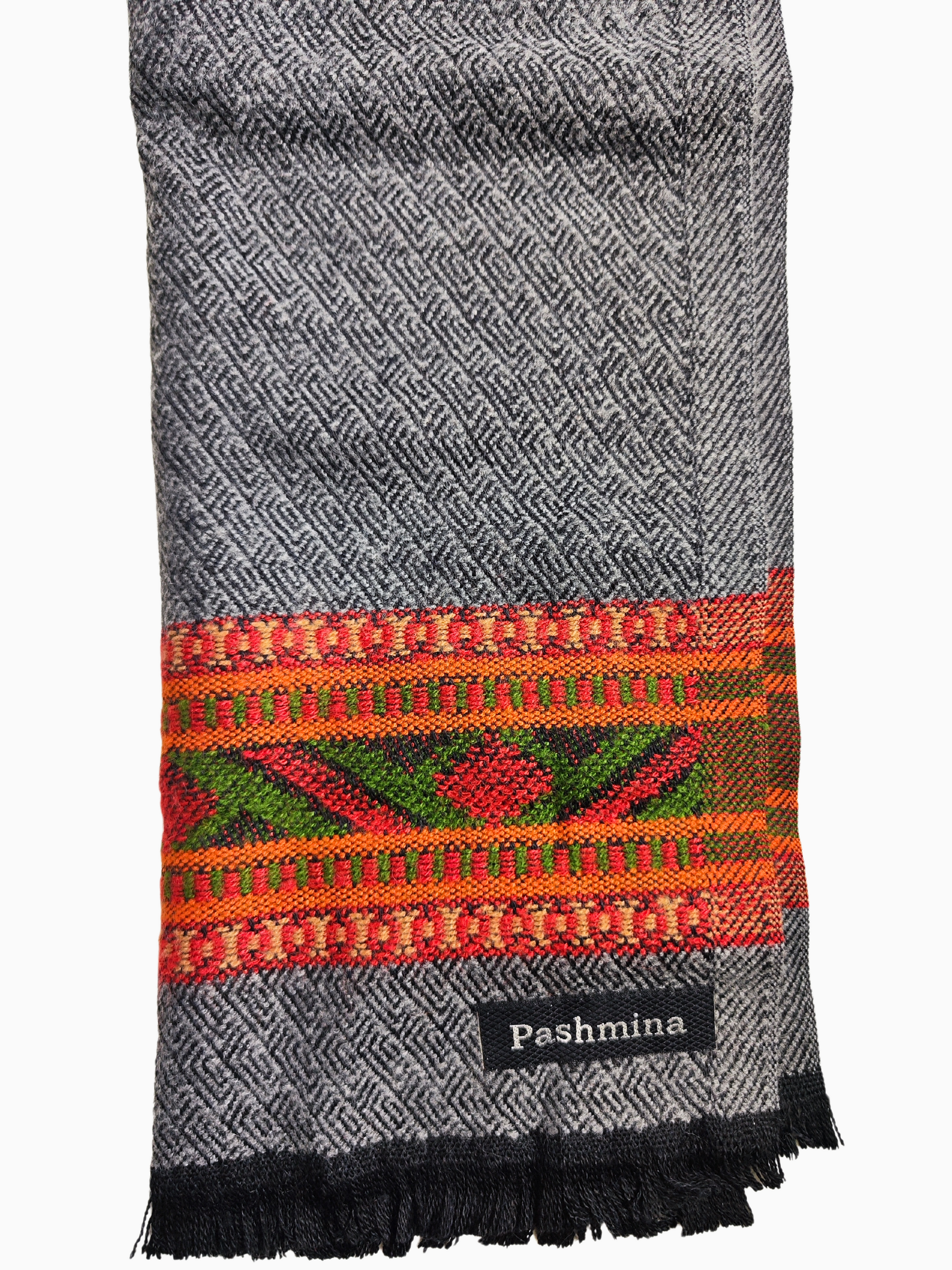 Écharpe vintage en laine grise avec un motif tribal tissé à la main dans des tons de rouge, orange et vert. L'écharpe a une frange à la base