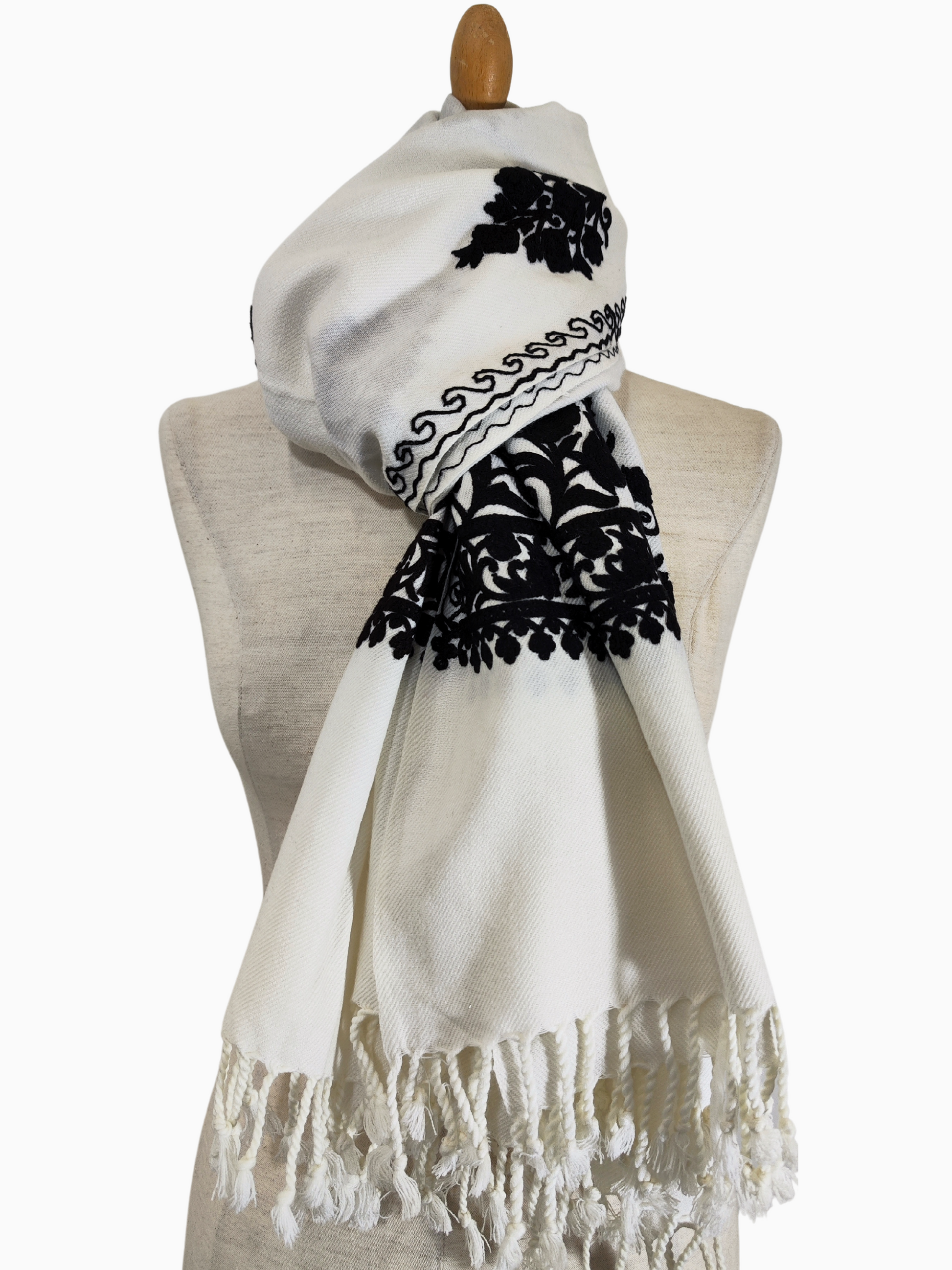 Xaile de lã bordado Aari de Caxemira, com motivos florais intrincados sobre um fundo branco. Um luxuoso xaile de lã de Caxemira, com intrincados bordados Aari e delicados motivos florais. O xaile branco apresenta bordados pretos e um rebordo com franjas. Xaile bordado Aari. Xaile de caxemira. xaile de lã. xaile bordado. Xaile indiano. Xaile de pashmina