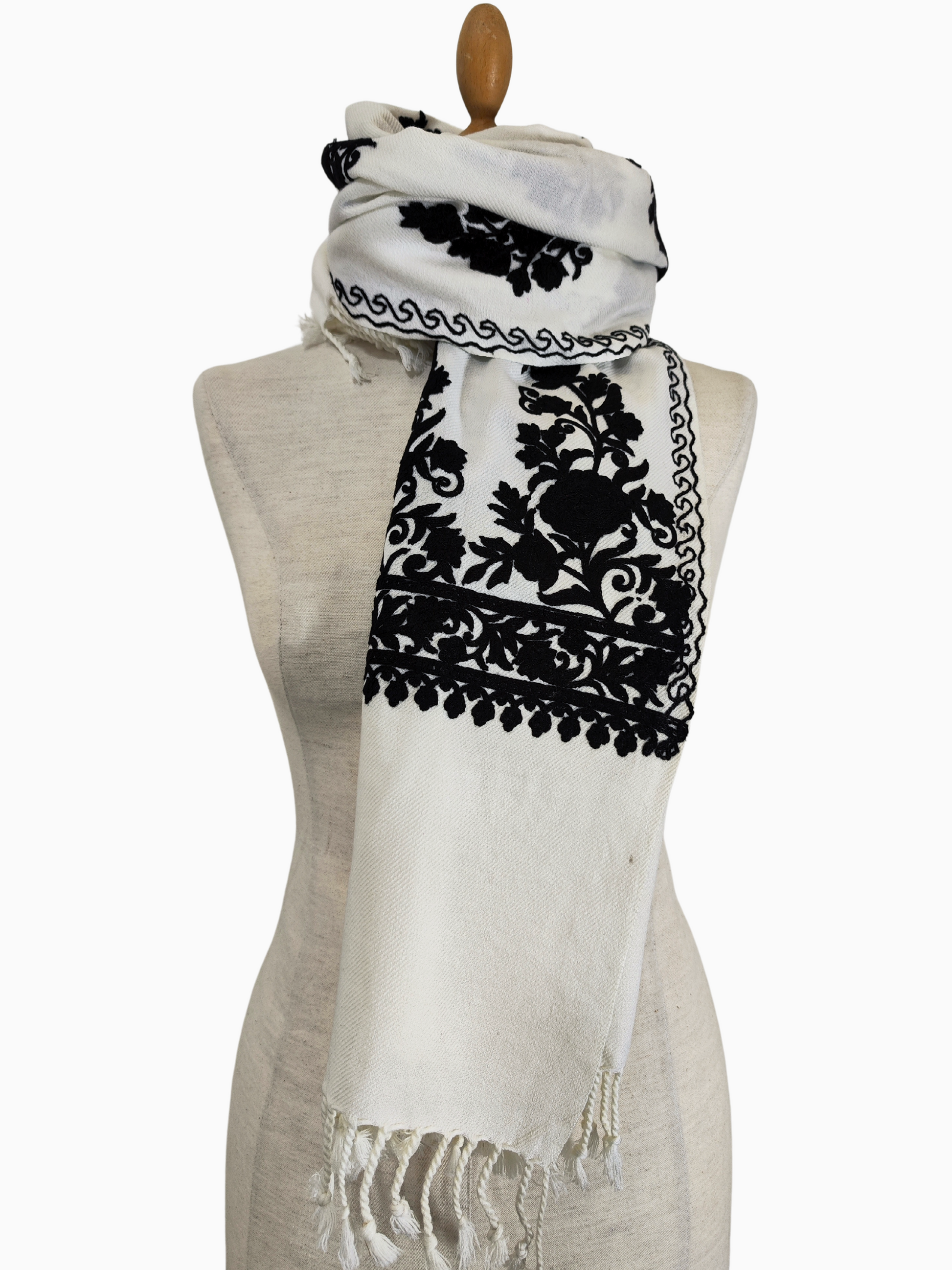 Aari bestickter Wollschal aus Kaschmir mit komplizierten Blumenmotiven auf weißem Grund. Ein luxuriöser Wollschal aus Kaschmir, der eine aufwendige Aari-Stickerei mit zarten Blumenmotiven zeigt. Der weiße Schal ist mit schwarzen Stickereien und einem Fransenrand versehen. Aari-Stickerei-Schal. Kaschmir-Schal. Wollschal. Bestickter Schal. Indischer Schal. Pashmina-Schal