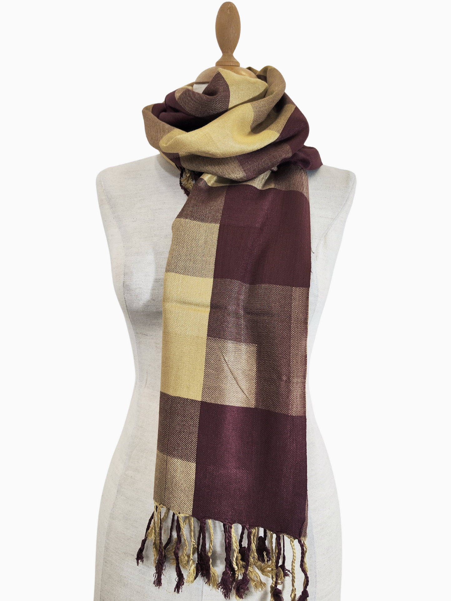 Ein brauner und gelber Schal aus einer goldfarbenen Baumwoll-Seidenmischung mit Karomuster, der über eine Schaufensterpuppe drapiert ist.
Ein weicher Pashmina-Schal mit einem geometrischen Muster aus braunen und gelben Quadraten. Er wird über die Schultern einer Schaufensterpuppe drapiert und hat am unteren Ende Quasten.
Ein karierter Pashmina-Schal in Braun- und Gelbtönen, der ein geometrisches Muster aufweist. Er ist auf einer Schaufensterpuppe ausgestellt.