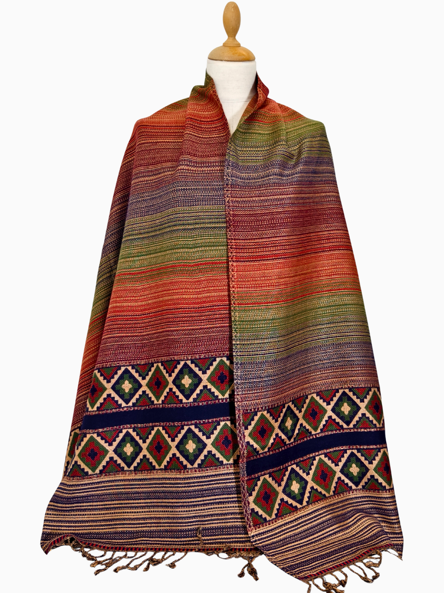 Colorful striped shawl with geometric patterns on a mannequin against a white background Bunter gestreifter Schal mit geometrischen Mustern auf einer Schaufensterpuppe vor weißem Hintergrund