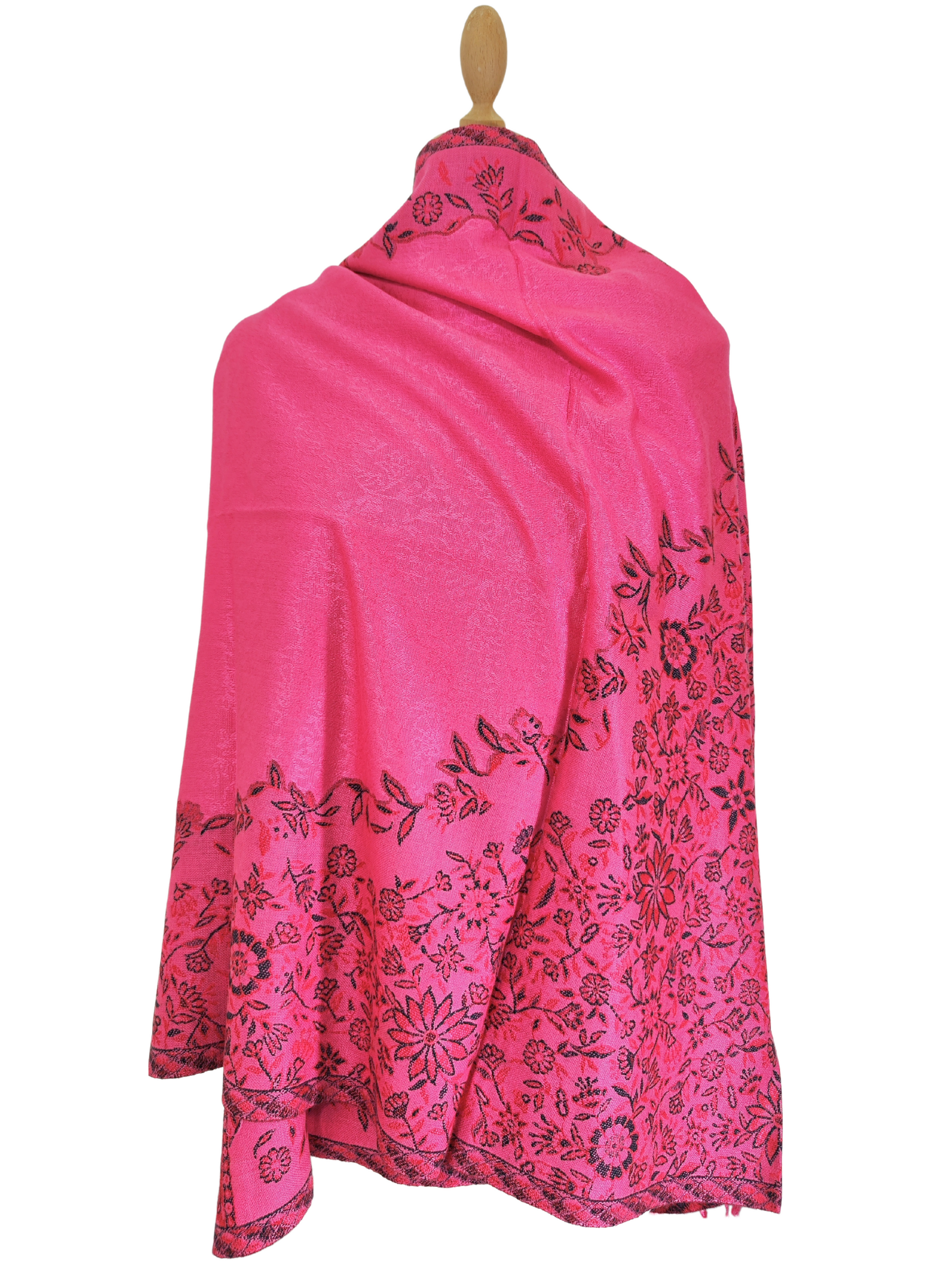 Scialle in pashmina rosa acceso ornato da intricati motivi floreali neri. Lo scialle presenta un bordo con frange ed è elegantemente drappeggiato su un manichino. Questo lussuoso accessorio è perfetto per aggiungere un tocco etnico a qualsiasi abbigliamento.