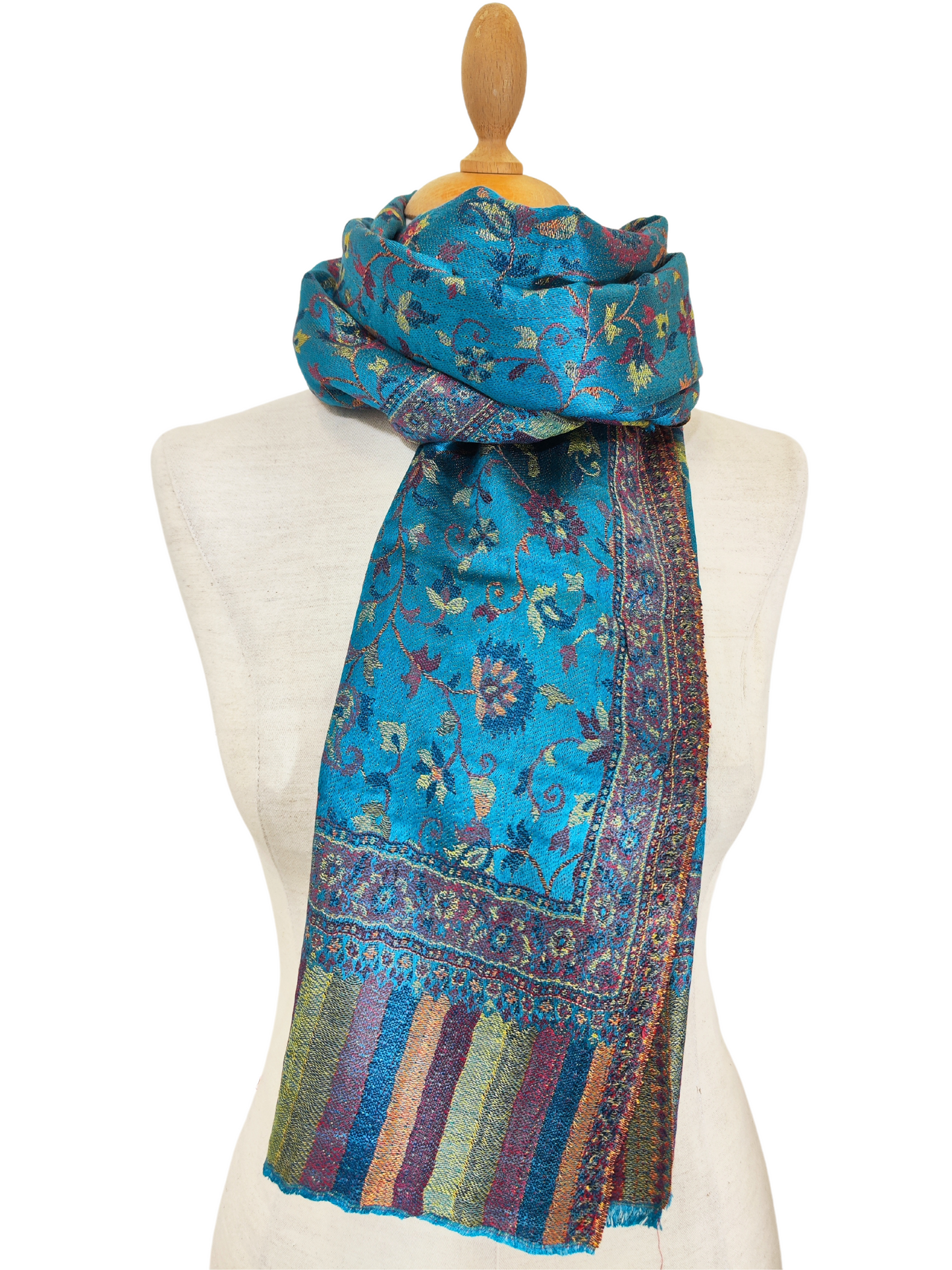 Turquoise Shawl with Colorful Floral Pattern
A vibrant turquoise shawl featuring an abstract floral design in shades of pink, yellow, orange, and blue, draped elegantly over a mannequin.