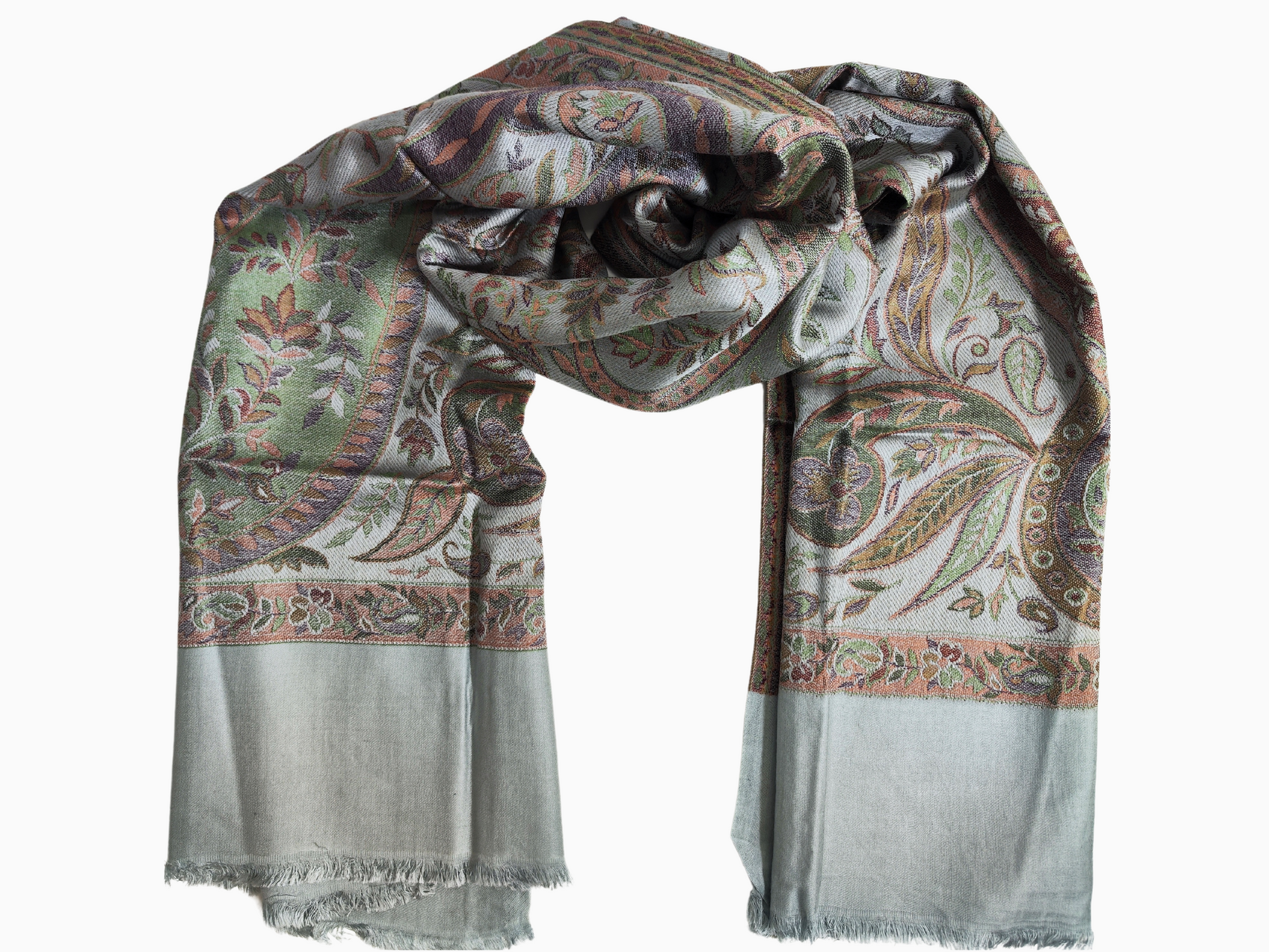 Scialle in pashmina blu chiaro con motivo paisley intrecciato a mano nei toni del marrone, dell'arancio e del verde. Lo scialle ha bordi sfrangiati.
Un lussuoso scialle in pashmina con un classico disegno paisley. Lo scialle, drappeggiato su un manichino, ha uno sfondo azzurro con dettagli intricati in colori caldi.