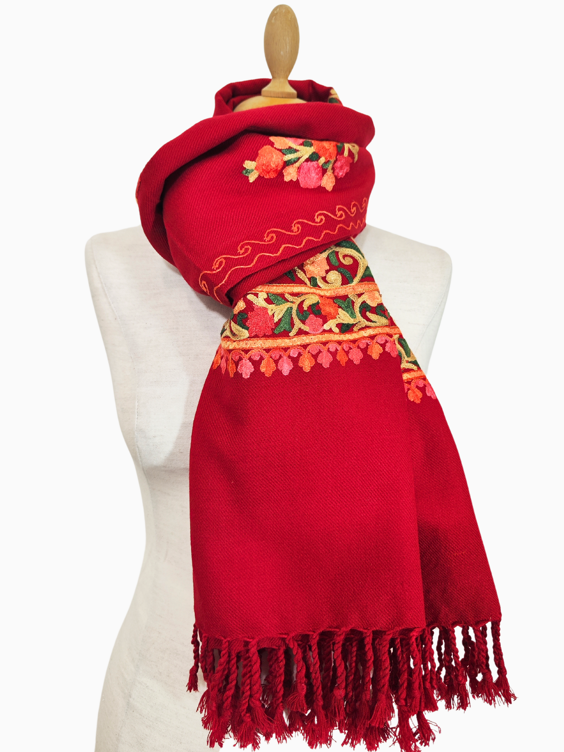 Un luxueux châle en pashmina rouge, orné de broderies florales complexes dans les tons orange, jaune, vert et rose.
Un magnifique châle en pashmina fait à la main, avec un col montant et une bordure frangée, orné d'une délicate broderie florale.