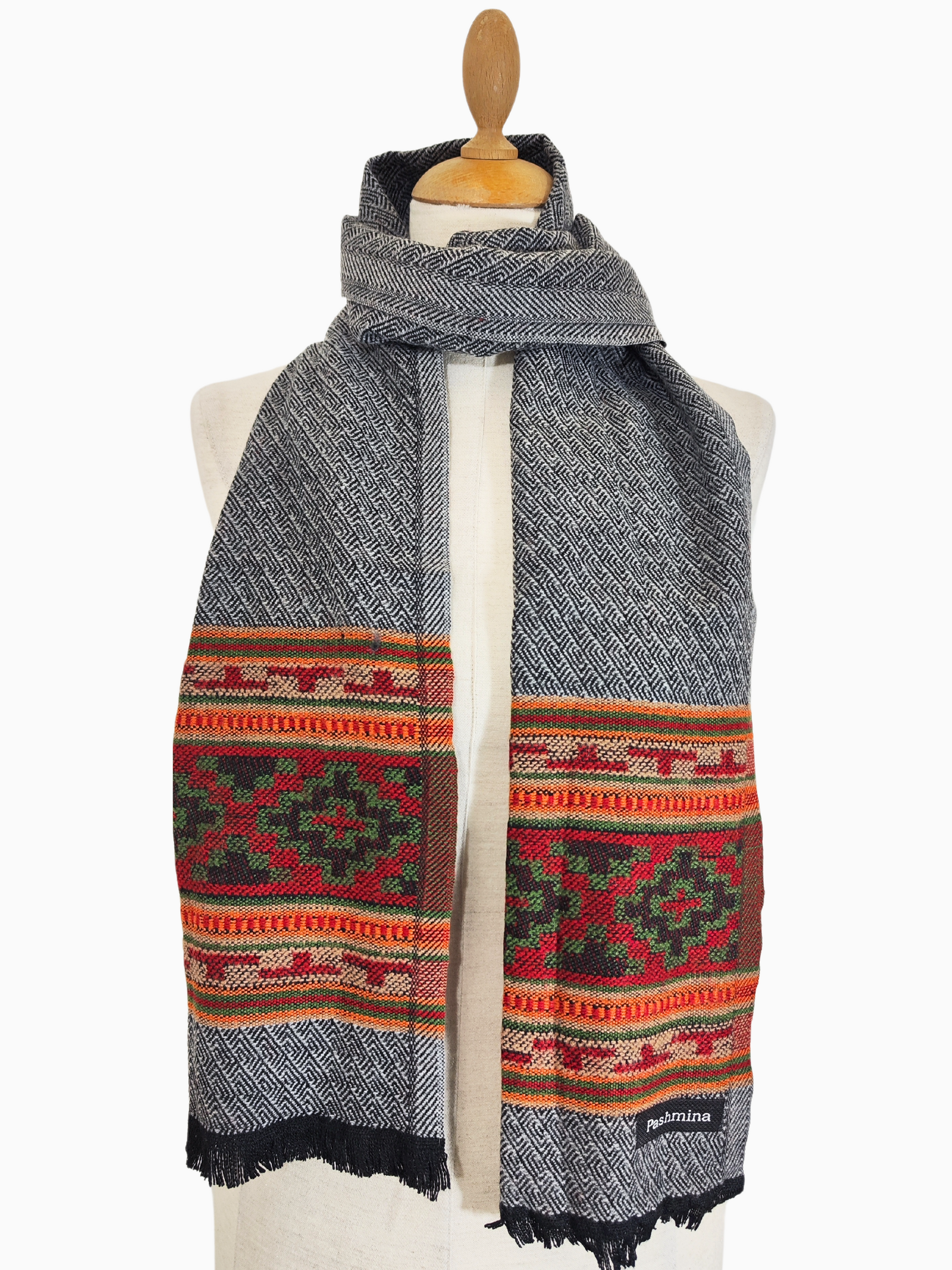 Écharpe vintage en laine Pashmina gris clair avec motif tribal coloré à large bordure

Cette écharpe vintage en laine est un magnifique mélange de style classique et de couleurs vives. Le corps principal de l'écharpe est d'un gris doux et chaud, tandis que le bord inférieur présente un motif frappant de triangles colorés dans des tons de rouge, d'orange et de vert.