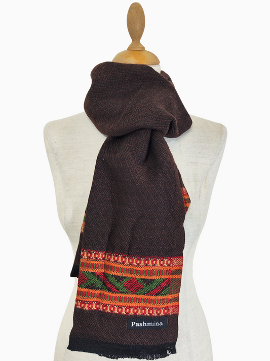 Dunkelbrauner Wollschal mit Tribal-Muster im Vintage-Stil, der im Winter für Wärme und Stil sorgt. Dieses Accessoire im Boho-Chic kombiniert kuscheligen Komfort mit einer zeitlosen Tribal-Ästhetik, perfekt für kaltes Wetter und lässige Schichten.