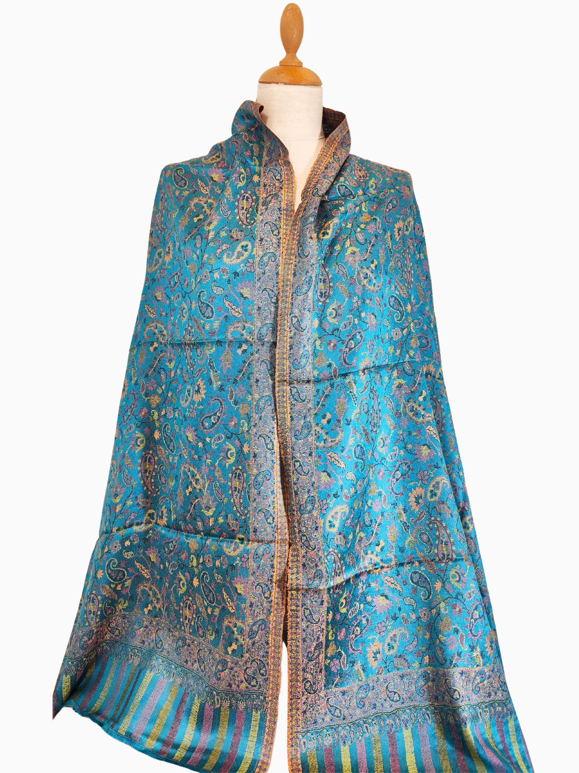 Superbe châle pashmina turquoise au motif cachemire vibrant. Fabriqué à partir d'un mélange de soie et de laine pour un toucher luxueux.
Châle pashmina turquoise vibrant avec un motif cachemire complexe.