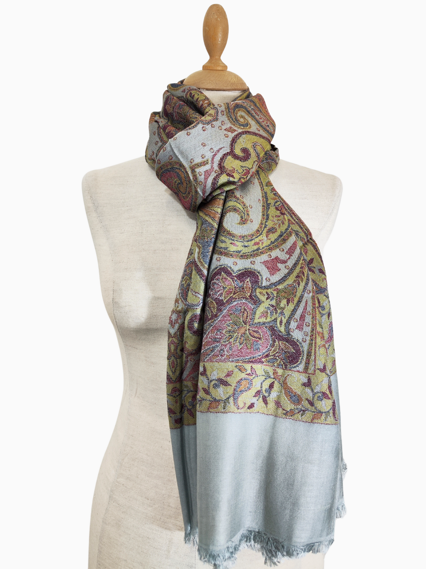 Sciarpa pashmina reversibile in misto lana e seta con un intricato motivo paisley, bordo azzurro e accenti floreali multicolori.
Un'ampia sciarpa rettangolare di colore azzurro, decorata con un vivace motivo paisley nei toni del giallo, del marrone e del rosa. La sciarpa presenta un bordo sfrangiato.