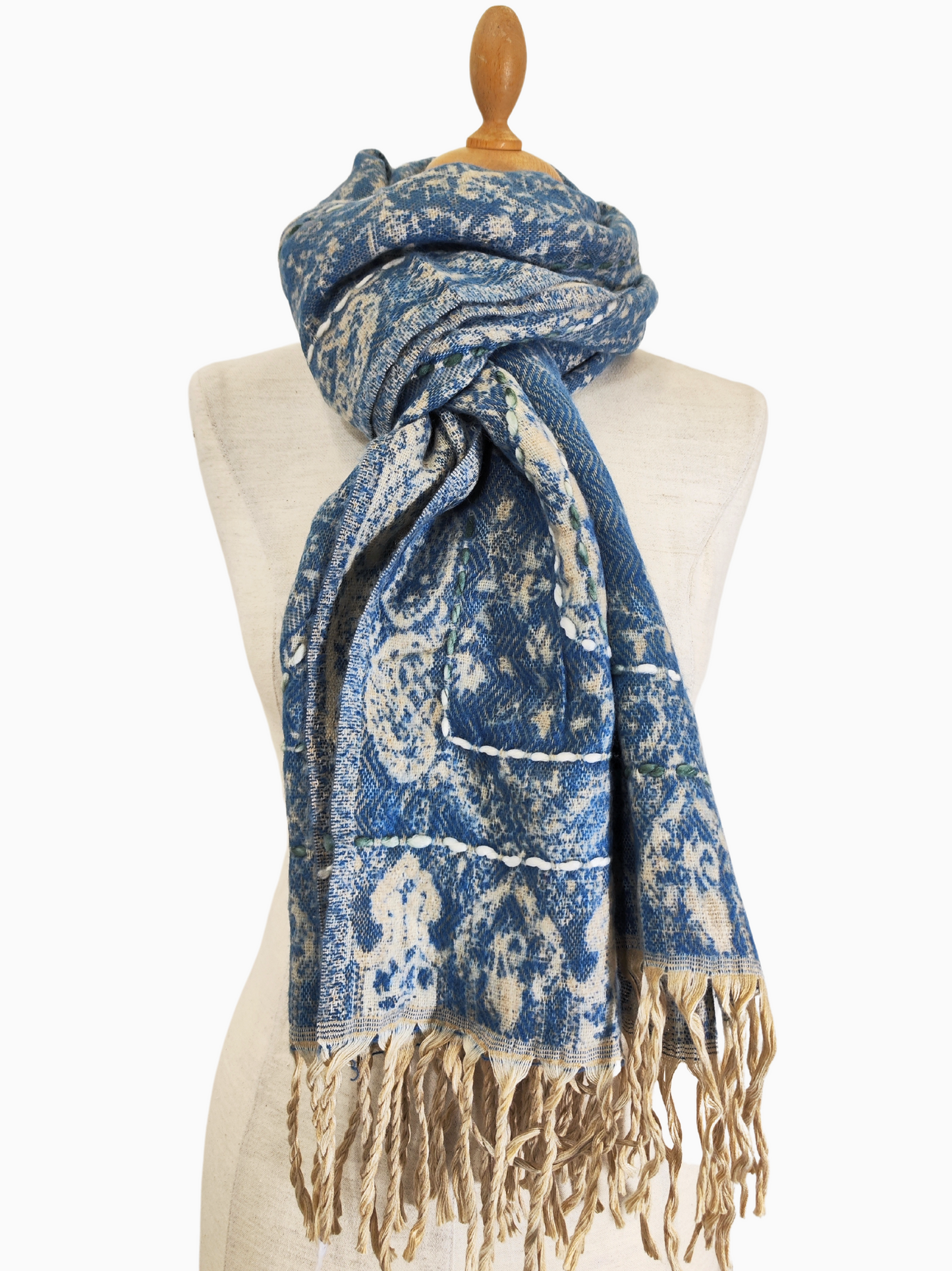 A luxurious reversible shawl crafted from fine Kashmir lamb's wool, featuring a delicate floral pattern and elegant tassels. Reversible floral shawl in blue and beige with tassels. The reversible shawl is in Blue and Beige colour