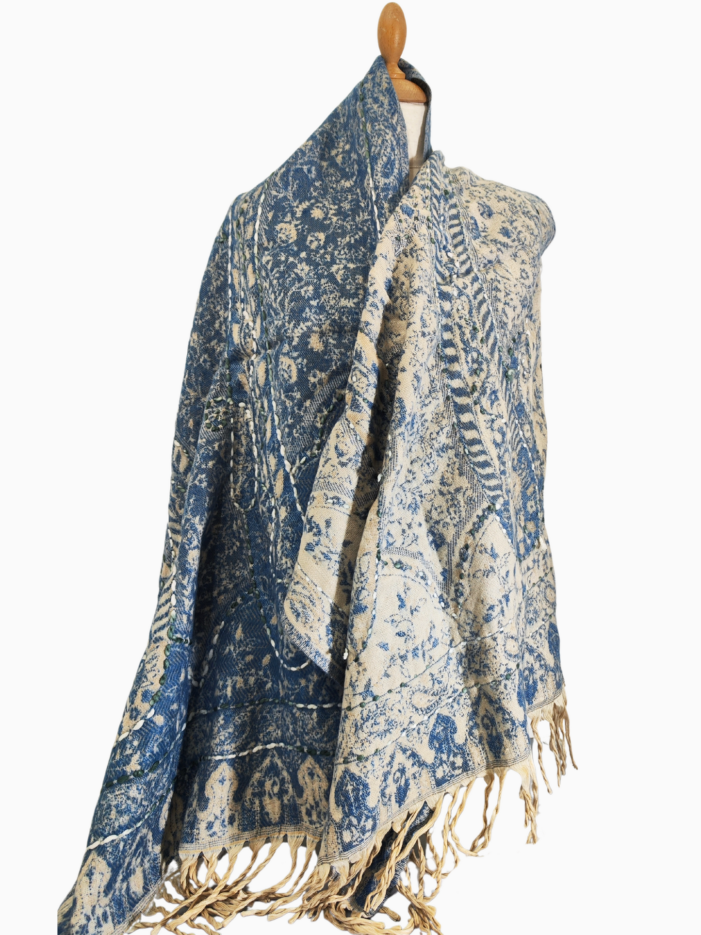 Un luxueux châle réversible en fine laine d'agneau du Cachemire, orné d'un délicat motif floral et d'élégants pompons. Châle floral réversible en bleu et beige avec pompons. Le châle réversible est en bleu et en beige.