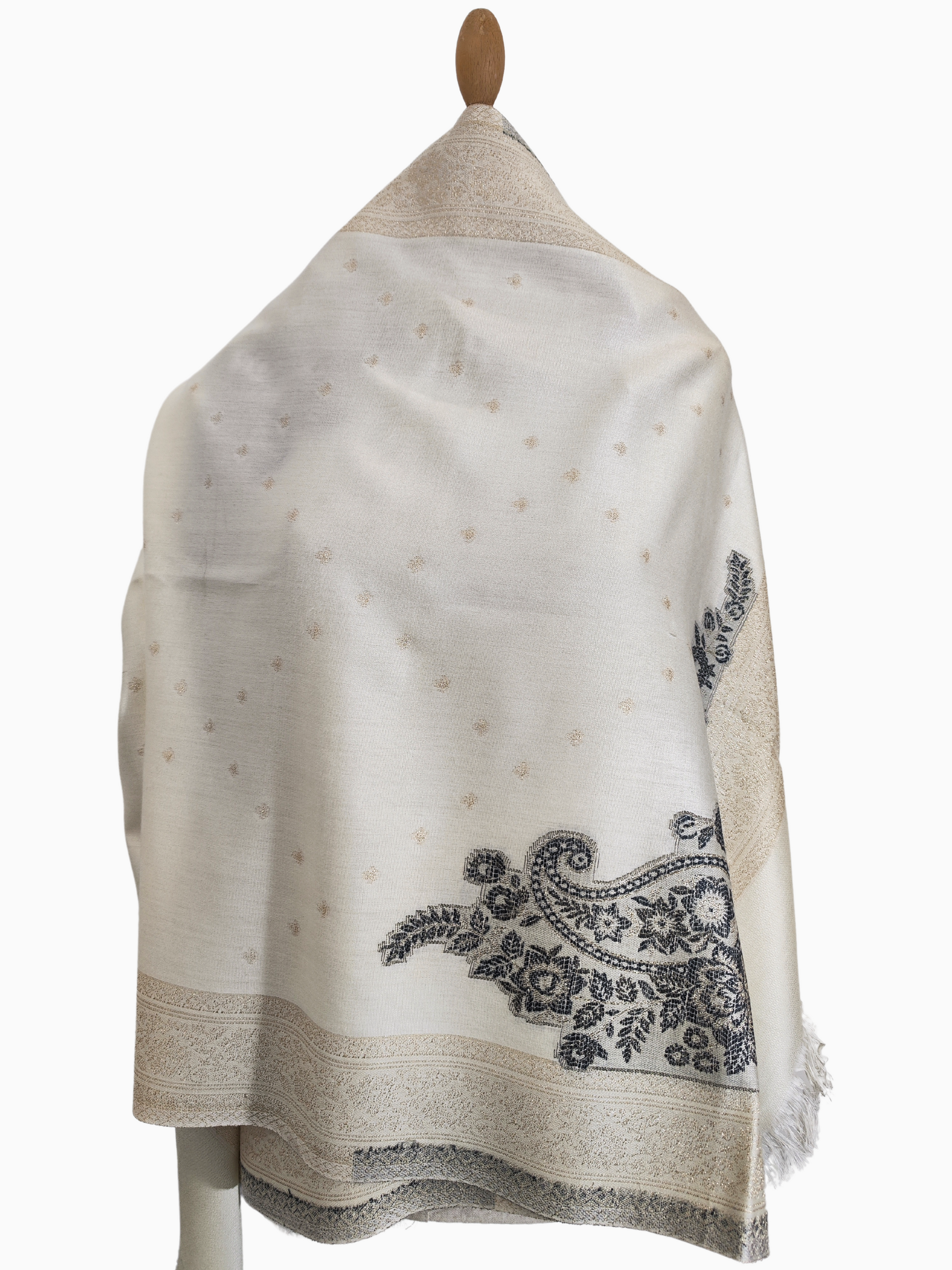 Extra-long ivory shawl made from a luxurious viscose, cotton, and silk blend, featuring intricate paisley and floral embroidery in a contrasting dark tone, subtle woven patterns throughout, and delicate fringes at the edges. Perfect for draping over shoulders, wrapping elegantly for warmth, or accessorizing formal and casual outfits, displayed on a mannequin for a full view of its design and length.