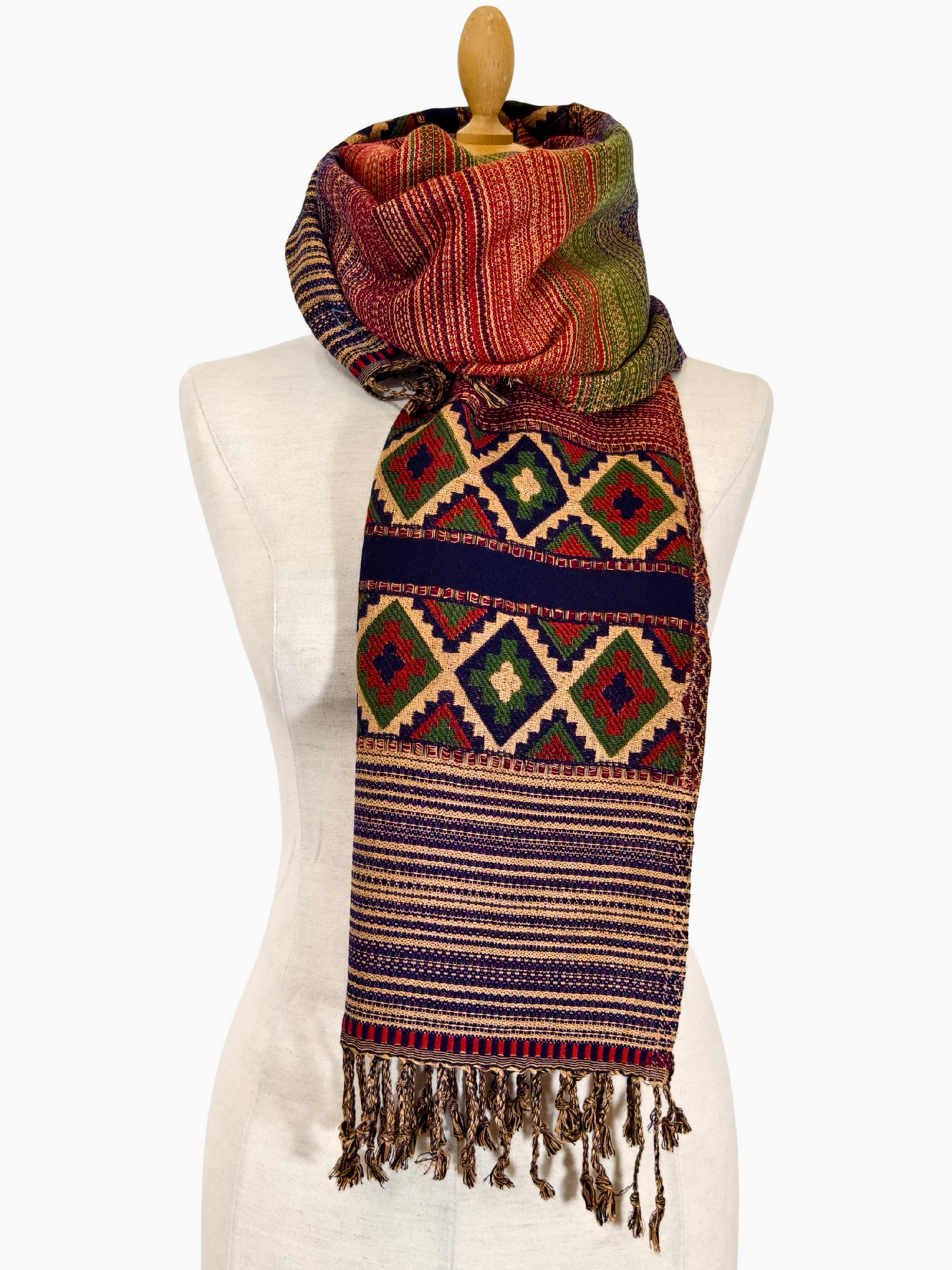 Colorful patterned scarf on a mannequin against a white background
Handwoven boho tribal shawl with multicolor stripes, geometric diamond patterns, and tassels. Ethnic wrap scarf handmade for men & women – Handgewebter Boho Schal mit Streifen, Rauten & Quasten. Kullu India Yak Wool